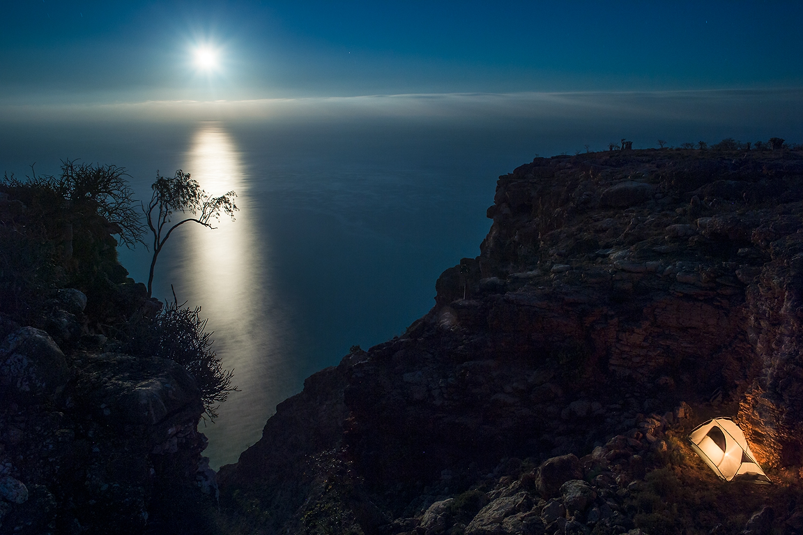 звездное небо и человек. луна на обрыве. ночной пейзаж. сумерки луна. скалы на луне.